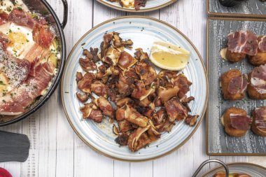 Domuz kulağı, önce kaynatılmış, sonra ızgara, içi sulu ve dışarıda kızartılmış, bir dilimde servis edilmiş.