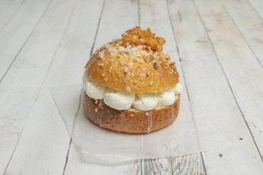 Fotoğraf, bir ya da iki mini Roscn kekinin dekorasyonuna odaklanır, kremanın yan yarıktan zarif bir şekilde baktığı, ve şekerli meyvenin