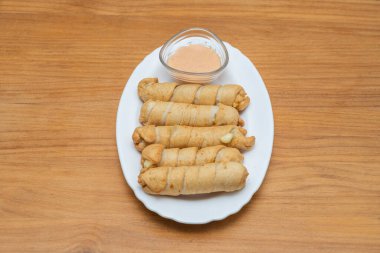 Hamurun altın sarılışı: peynirin etrafına puf böreği sarma sürecinin samimi bir yakın çekimi, her ısırığın yoğunlaştırılmış lezzet patlaması olmasını sağlar.