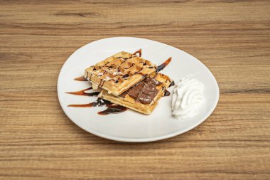 Yuvarlak, kare ve kalp şeklindeki waffle 'ların bulunduğu bir tepside şekiller ve boyutlar incelenerek, esmerleşmenin tekdüzeliğini değerlendirilir.