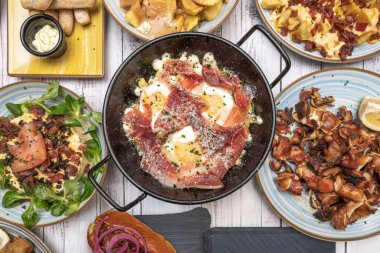 Kırık yumurta, jambon ve ızgara biftekle kombinasyon tabağı. Ekstra proteinli daha eksiksiz bir yemek için.