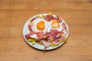 Jambonlu kırık yumurta ve sotelenmiş kuşkonmaz, yeşil sebzelere bir tutam ekleyen bir karışım.