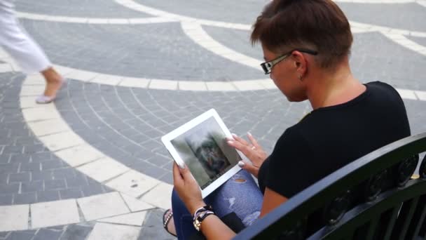 Giovane donna con tablet seduto nel parco della città — Video Stock