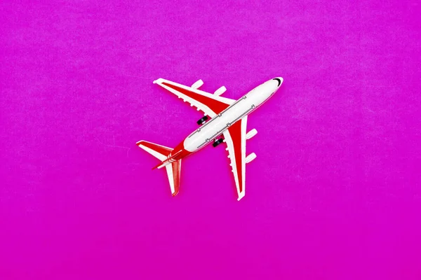빨간색 바탕에 흰색과 빨간색 여객 모델 비행기가 있습니다. 텍스트를 위한 자유 공간. 여행 개념. — 스톡 사진