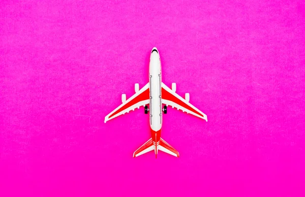 White and red Passenger Model airplane on a red, pink background. Свободное место для текста. Концепция путешествия. — стоковое фото