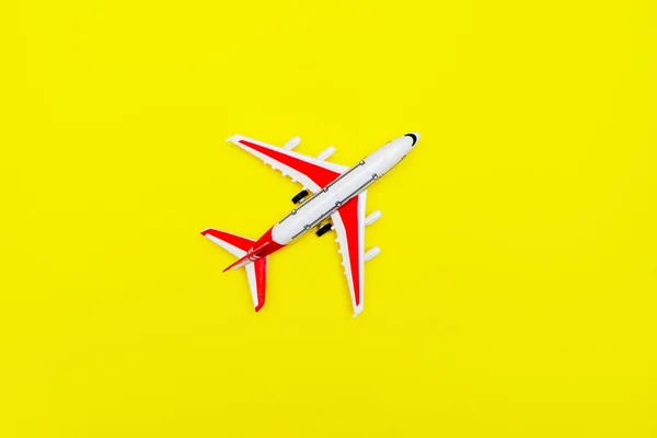 Avión modelo Pasajero blanco y rojo sobre fondo amarillo. Espacio libre para texto. Concepto de viaje. —  Fotos de Stock