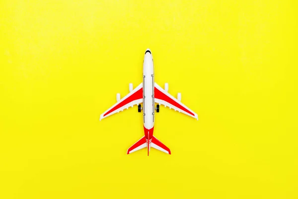 Avion modèle passager blanc et rouge sur fond jaune. Espace libre pour le texte. Concept de voyage. — Photo
