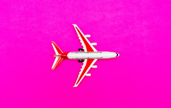 白色和红色乘客模型的飞机在红色，粉红色的背景。自由的文字空间。旅行概念. — 图库照片