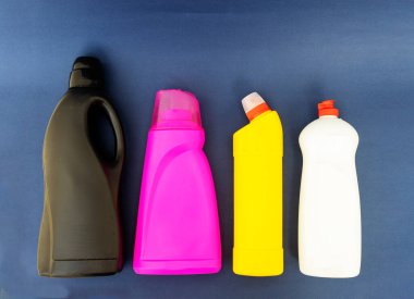 çok renkli plastik şişeler ve mavi arka planda bulunan kimyasallar için ev eşyaları.