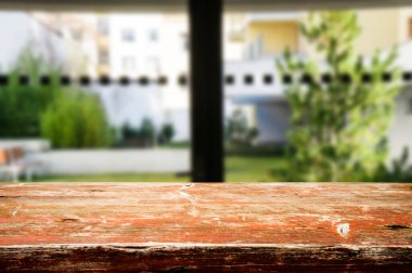 Evin bulanık koridoru, geçidi ve avlusuna karşı ahşap masa üstü. Ürün görüntüleme montajı veya tasarımı için görüntünün kilit noktasıdır..