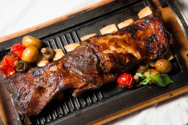 Ahşap masada kızarmış kuzu budu. Kafkas mutfağından tabaklar