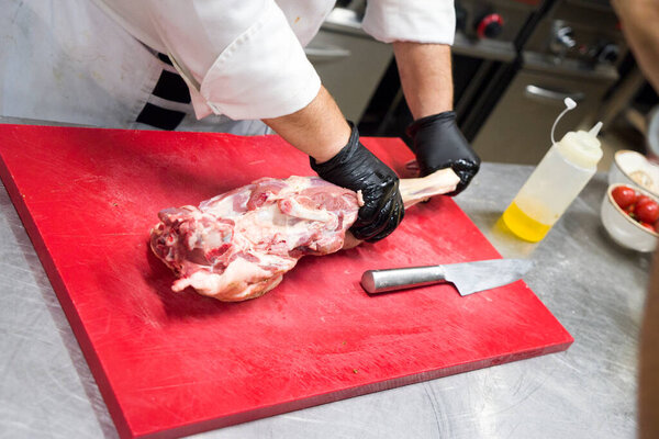 The chef also prepares lamb shank dishes. The process of cooking lamb shank male chef in a professional kitchen. Cooking meat in a Caucasian restaurant.