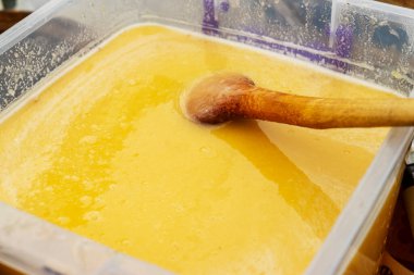 Bal peteklerinin dokusu yakınlaşıyor. Plastik kaplarda bal bulunan sarı balmumu petekler. Panayırda ev yapımı bal satışı.