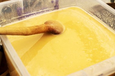 Bal peteklerinin dokusu yakınlaşıyor. Plastik kaplarda bal bulunan sarı balmumu petekler. Panayırda ev yapımı bal satışı.