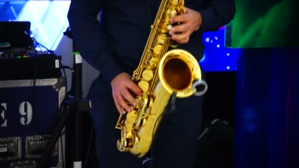 Musician is playing on saxophone in concert. Close-up on fingers pressing the keys of the instrument — Stock Video