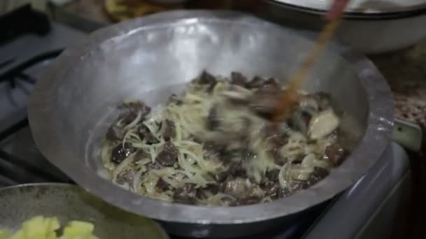 In cucina. Cucino. La donna per preparare il cibo da patate, cipolle, rene di manzo e fegato nella padella . — Video Stock