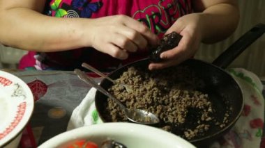 masada bir kadının yakın çekim dolması et, domates, biber ve patlıcan rulo hazırlanması