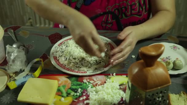 Großaufnahme von Frauenhänden bei der Zubereitung und dekoriert mit Gemüsesalat in der Küche — Stockvideo