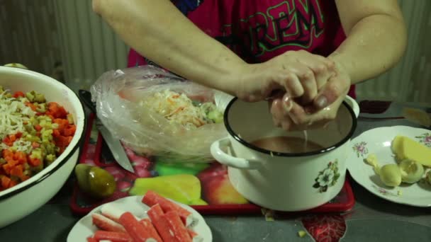 Close-up van vrouw handen voorbereiding, en versierd met groente salade in de keuken — Stockvideo