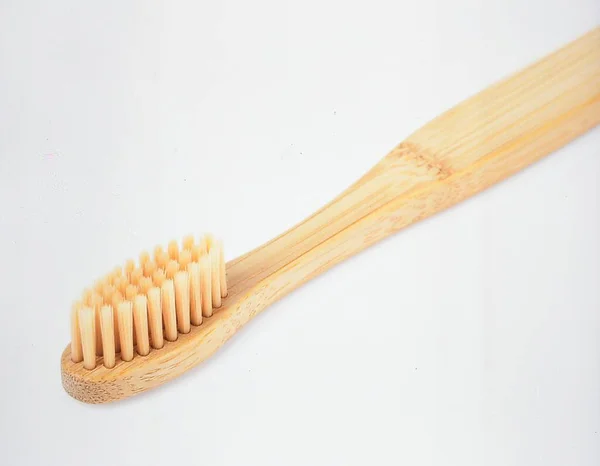 Bambu diş fırçası beyaz arka planda izole edilmiş, Sürdürülebilir Yaşam Tarzı ve Plastiksiz Hijyen Konsepti İçin Çevre dostu Oral Bakım Ürünü