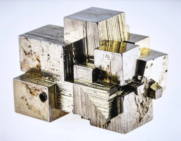 Metalik parlak ve geometrik formasyonlara sahip, saf beyaz arkaplanda izole edilmiş bir Pyrite küp kümesi..