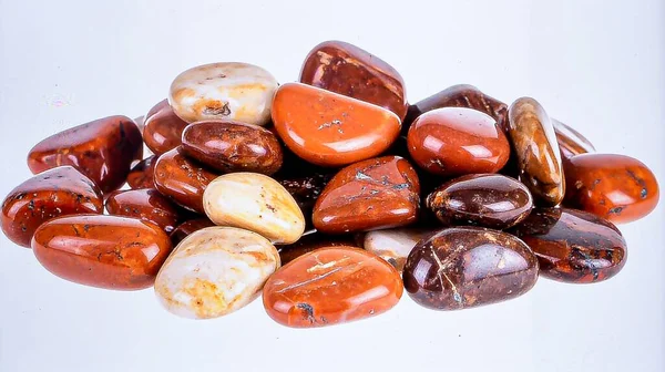 Toprakta kırmızı ve kahverengi desenli, temiz beyaz arka planda izole edilmiş, devrilmiş levrek taşı yığını..