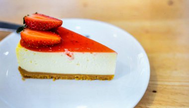 Klasik New York Cheesecake ve Çilek Toplama Beyaz Tabakta En İyi Tatlı Nesnesi ve Gurme Gıda Konseptiyle servis ediliyor.