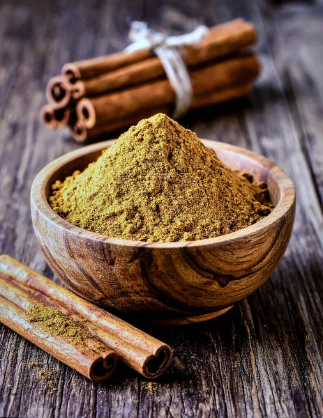 Özel Baharat Nesnesi ve Geleneksel Mutfak Malzemeleri Konsepti için Kırsal Tahta Kasede Tarçın Sopaları ve Tozu