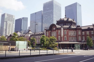 Tokyo, Japonya - 1 Eylül 2025 - Güneşli bir günde arka planda modern cam gökdelenleri olan Tokyo İstasyonu Marunouchi binasının ikonik kırmızı tuğla cephesi