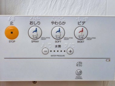 Körler alfabesi ile Japon bidet kontrol panelinin yakın çekim, sprey, yumuşak yıkama, dur ve su basıncı ayarlamaları için düğmeler.