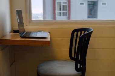 Minimalist Workspace With Laptop And Chair By Window With Natural Light