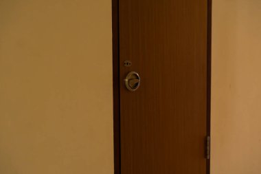 Pirinç saplı, ahşap kapılı ve delikleri desenli duvara dayanan