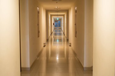 Sıcak Aydınlatma ve Yansıtıcı Döşemeli Uzun İç Otel Koridoru