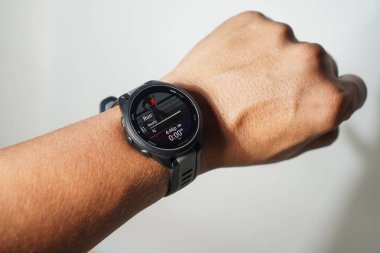 Güney Sulawesi, Endonezya, 13 Şubat 2026: Koşucu 165 için bir Garmin 'in yakın çekimi Bir adamın bileğindeki müzik saati, koşmaya hazır olduğunu gösteriyor.