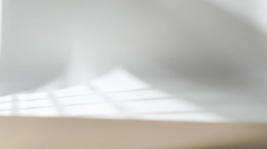 Yumuşak ışık ve gölge düz bir yüzey boyunca çapraz çizgisi olan desenli bir duvarda oynuyor.