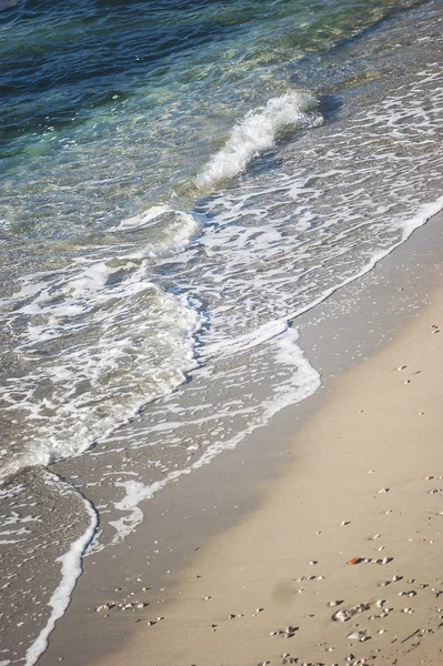 De golven aan een zandstrand — Stockfoto