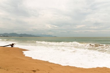 Bulutlu bir gün ve ana kumsalda dalgalar.
