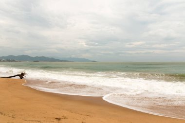 Bulutlu bir gün ve ana kumsalda dalgalar.