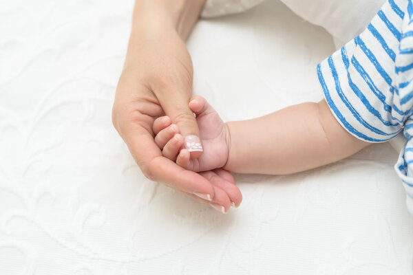 mother holding baby hand