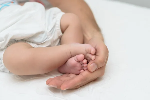 Mãe segurando pés de bebê — Fotografia de Stock