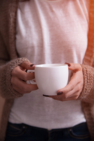 Close-up of coffee cup in woman hands