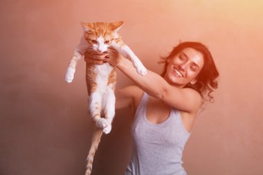 bir yavru kedi tutan kadın