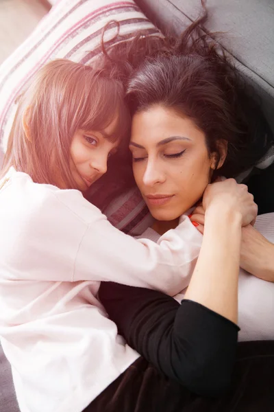 Genç anne ve kızı kanepede döşenmesi — Stok fotoğraf