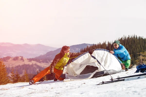 Deux randonneurs dans les montagnes d'hiver installant tente . — Photo