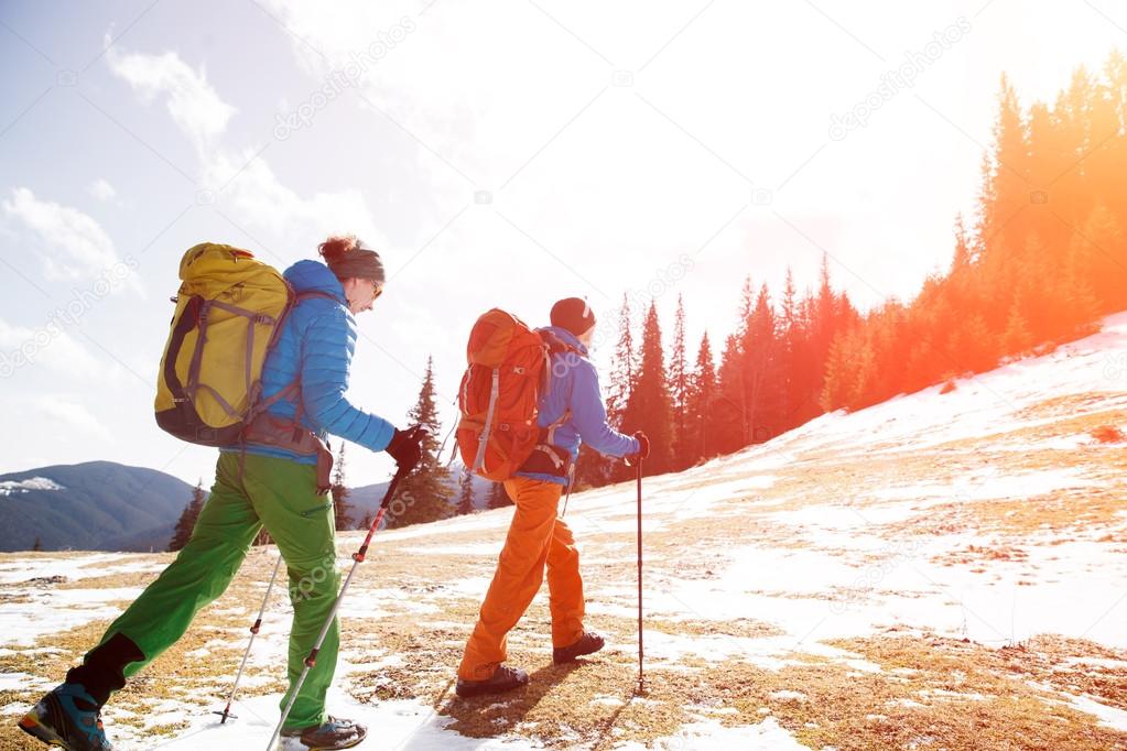 Two hikers in winter mountains installing tent