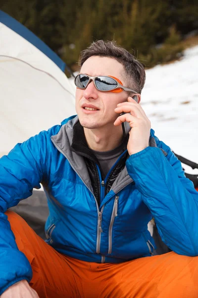 Caminante hablando en el teléfono inteligente en las montañas de invierno . — Foto de Stock