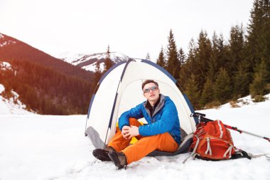 Uzun yürüyüşe çıkan kimse dağın üzerinde çadırda.