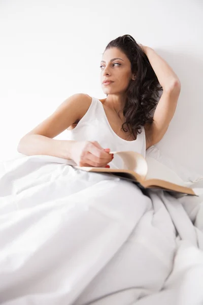 श्यामला लंबी बालों वाली महिला एक किताब पढ़ रही — स्टॉक फ़ोटो, इमेज