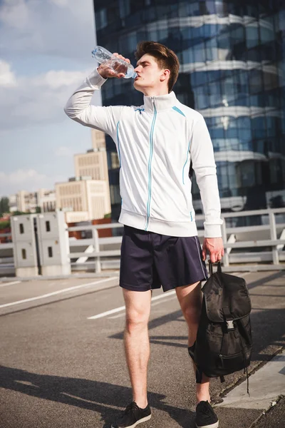 Adulto atleta masculino beber agua después de correr — Foto de Stock