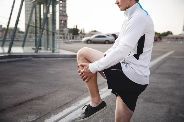 Atleta calentando y estirando antes de correr — Foto de Stock
